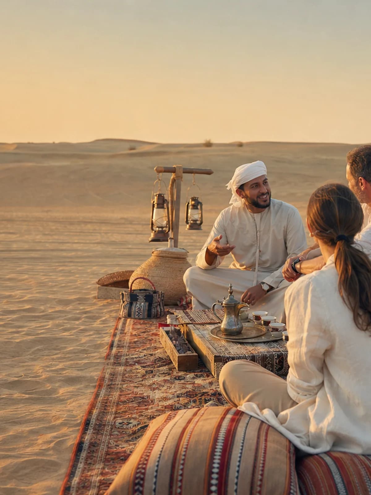 A private host sharing tea with a small group in Dubai's golden desert